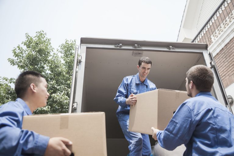 movers unloading a moving van, passing a cardboard box